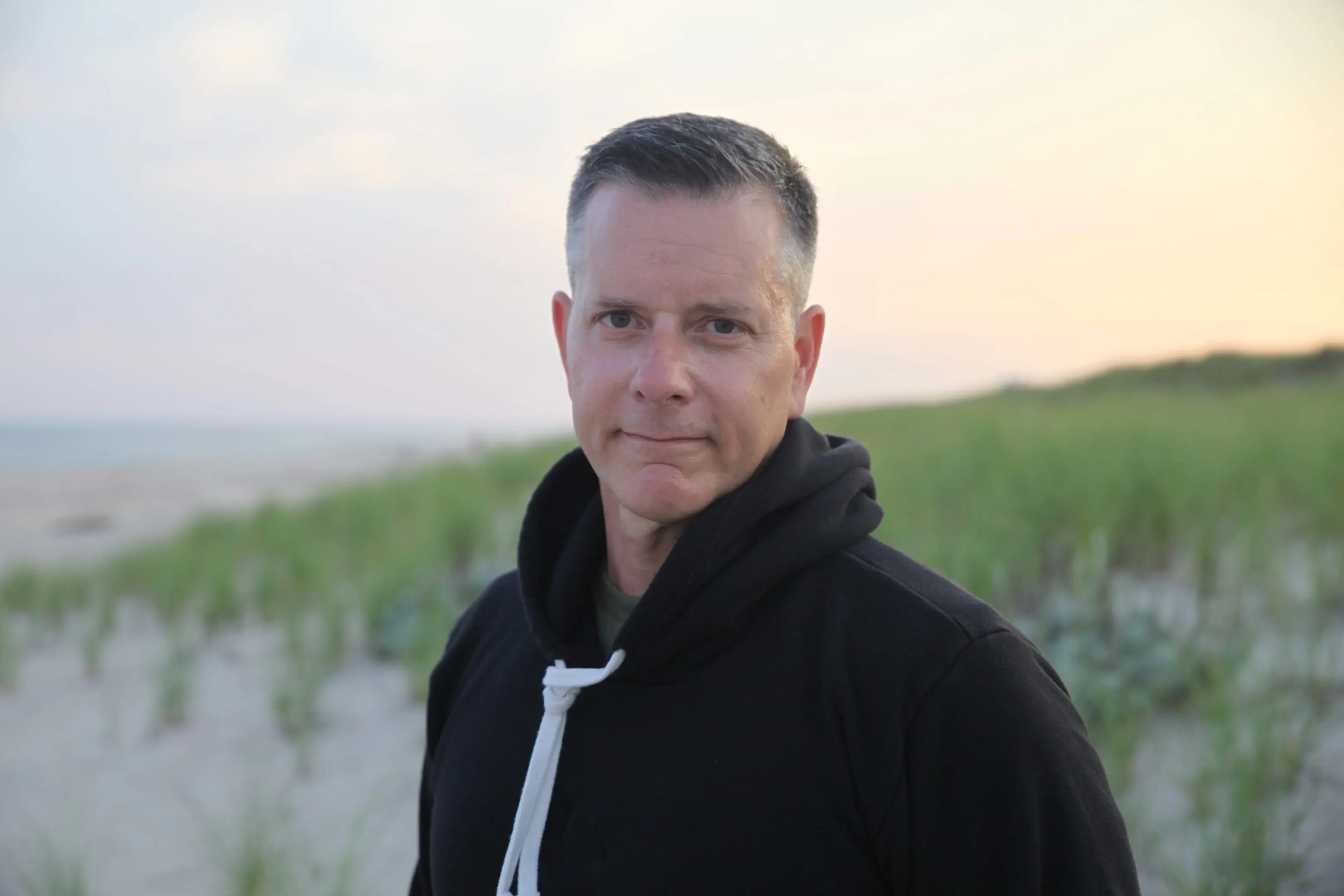 A man standing in front of some grass